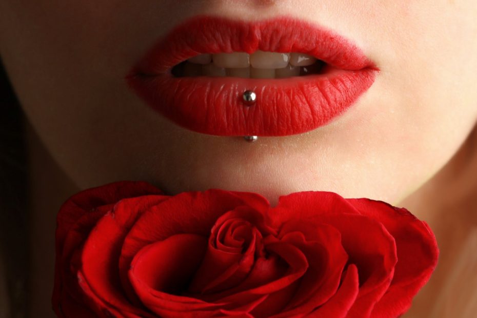 woman wearing red lipstick near red rose