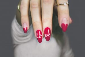 Manicura roja y blanca con estampado de corazones