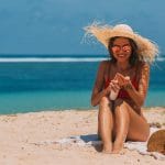 a woman in the beach using a sun screen product